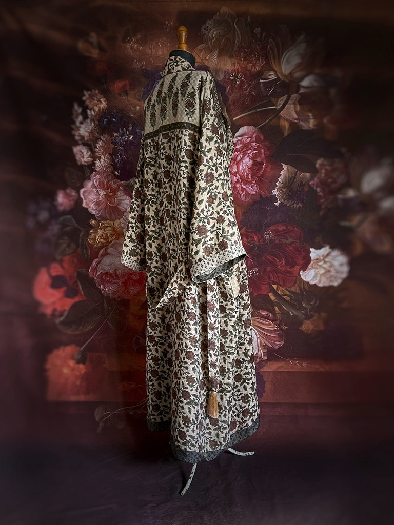 Chestnut brown and olive green fine wool dressing robe or duster coat with a design of Indienne florals. Wide sleeves, deep pockets, tassel sash. Lined in printed silk. Sustainably created from antique and vintage textiles by the Pavilion Parade studio.