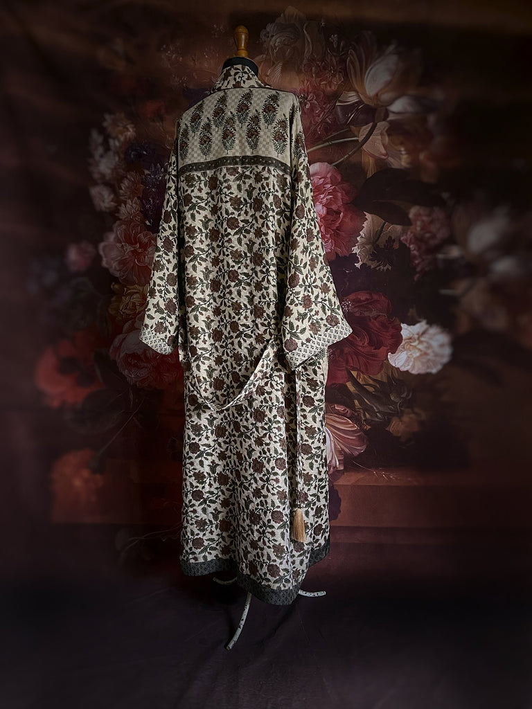 Chestnut brown and olive green fine wool dressing robe or duster coat with a design of Indienne florals. Wide sleeves, deep pockets, tassel sash. Lined in printed silk. Sustainably created from antique and vintage textiles by the Pavilion Parade studio.