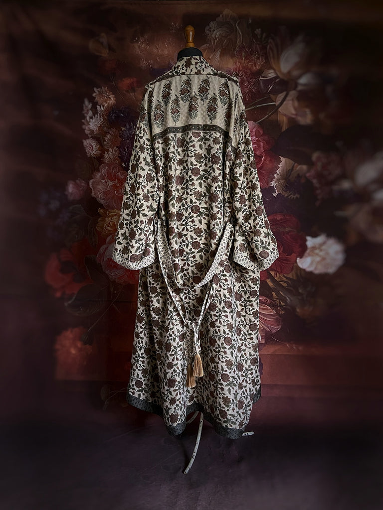 Chestnut brown and olive green fine wool dressing robe or duster coat with a design of Indienne florals. Wide sleeves, deep pockets, tassel sash. Lined in printed silk. Sustainably created from antique and vintage textiles by the Pavilion Parade studio.