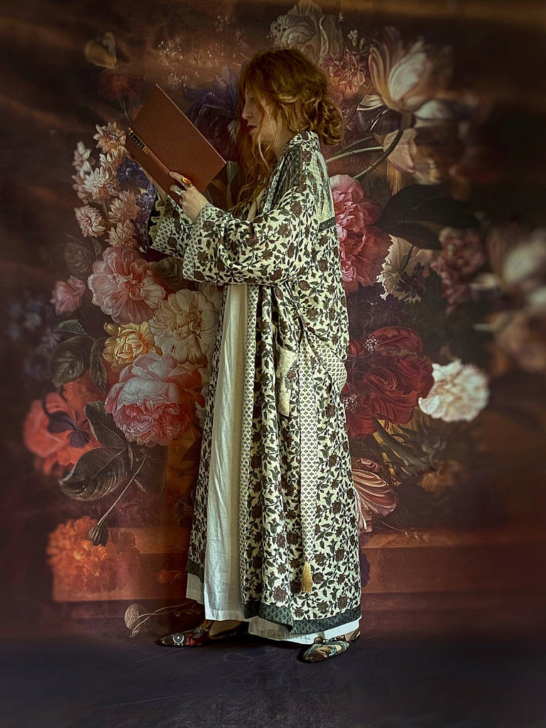Chestnut brown and olive green fine wool dressing robe or duster coat with a design of Indienne florals. Wide sleeves, deep pockets, tassel sash. Lined in printed silk. Luxury bohemian style sustainably created in the UK from antique and vintage textiles by the Pavilion Parade studio.