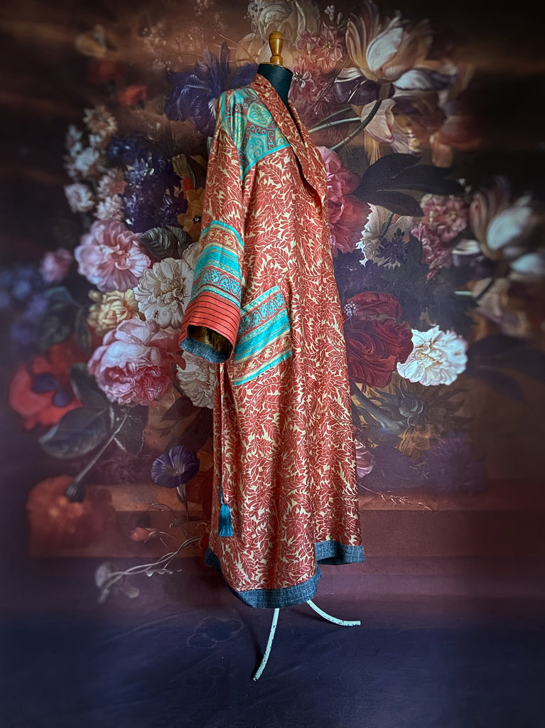 Luxury bohemian dressing robe or duster in a vibrant coral and turquoise palette, with wide sleeves, deep pockets, and tassel sash belt. Fully lined in colourful printed silk. Created from vintage and antique textiles by the Pavilion Parade studio.