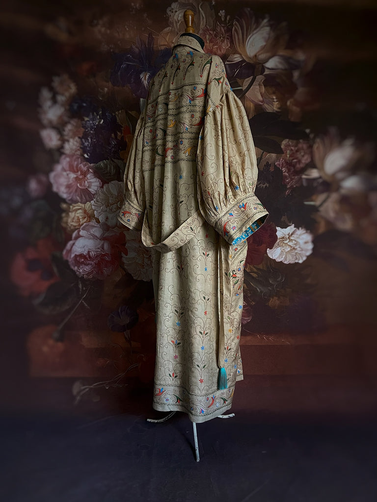 Circus hand embroidered kantha silk robe with balloon sleeves, oversize patch pockets and tassel sash.  Shades of azure blue, daffodil yellow, leaf green, orange  and pink on a warm honey ground. Lined in printed floral silk. Created from antique and vintage textiles by Pavilion Parade.
