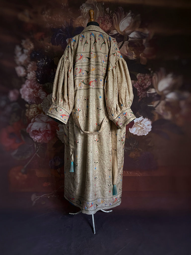 Circus hand embroidered kantha silk robe with balloon sleeves, oversize patch pockets and tassel sash.  Shades of azure blue, daffodil yellow, leaf green, orange  and pink on a warm honey ground. Lined in printed floral silk. Created from antique and vintage textiles by Pavilion Parade.
