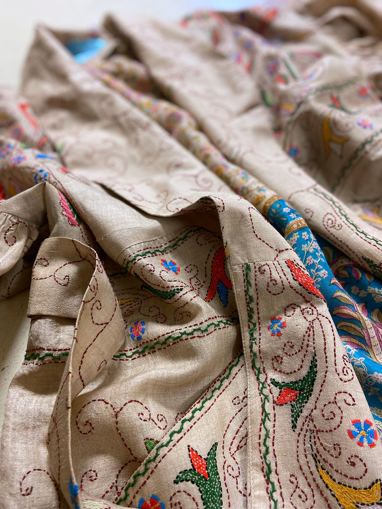 Circus hand embroidered kantha silk robe with balloon sleeves, oversize patch pockets and tassel sash.  Shades of azure blue, daffodil yellow, leaf green, orange  and pink on a warm honey ground. Lined in printed floral silk. Created from antique and vintage textiles by Pavilion Parade.