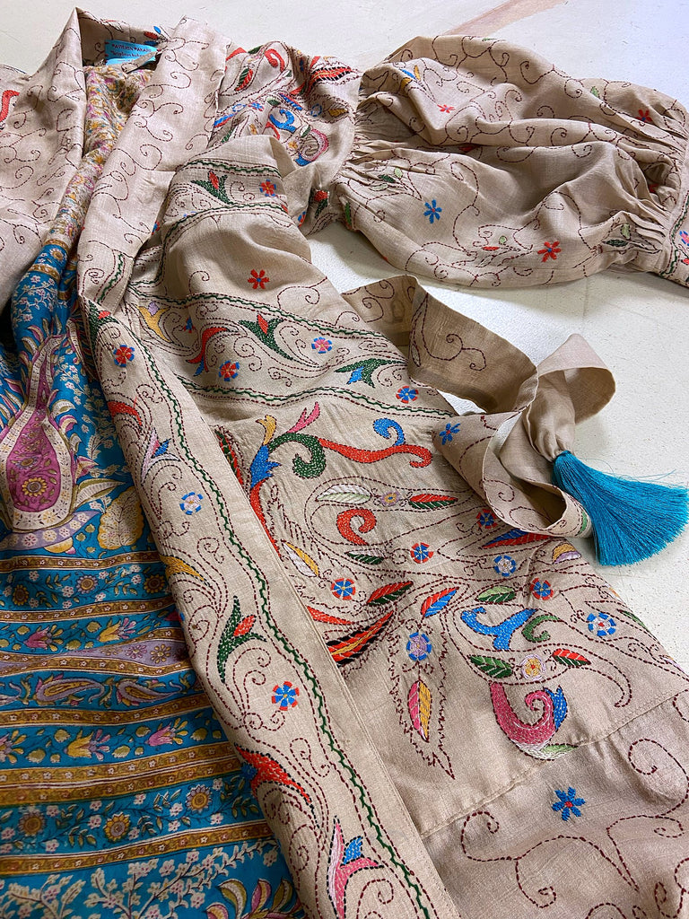 Circus hand embroidered kantha silk robe with balloon sleeves, oversize patch pockets and tassel sash.  Shades of azure blue, daffodil yellow, leaf green, orange  and pink on a warm honey ground. Lined in printed floral silk. Created from antique and vintage textiles by Pavilion Parade.