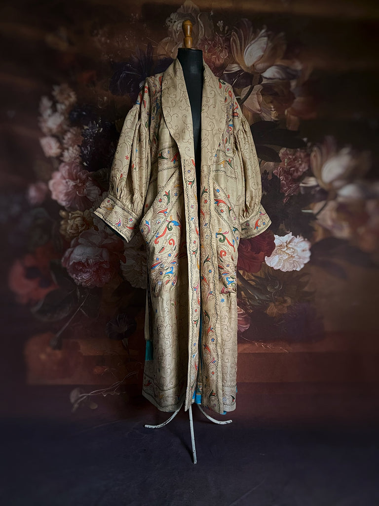 Circus hand embroidered kantha silk robe with balloon sleeves, oversize patch pockets and tassel sash.  Shades of azure blue, daffodil yellow, leaf green, orange  and pink on a warm honey ground. Lined in printed floral silk. Created from antique and vintage textiles by Pavilion Parade.