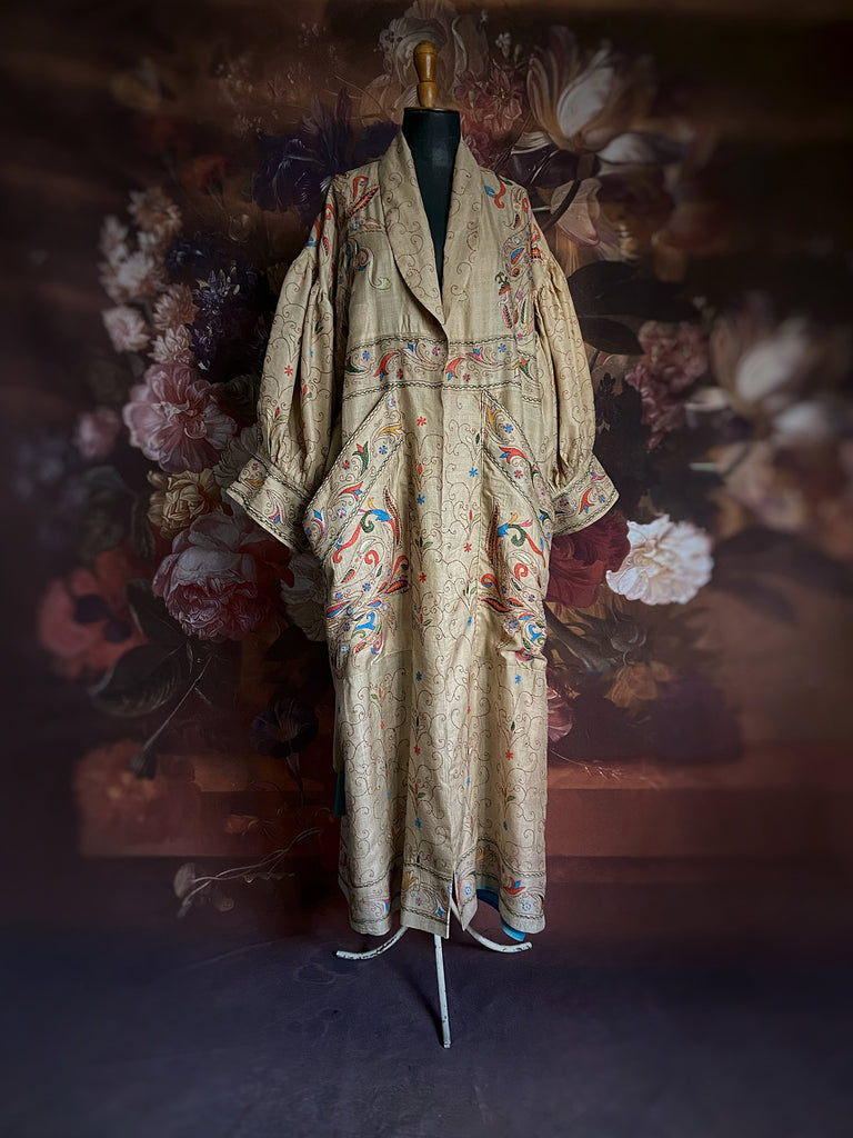 Circus hand embroidered kantha silk robe with balloon sleeves, oversize patch pockets and tassel sash.  Shades of azure blue, daffodil yellow, leaf green, orange  and pink on a warm honey ground. Lined in printed floral silk. Created from antique and vintage textiles by Pavilion Parade.