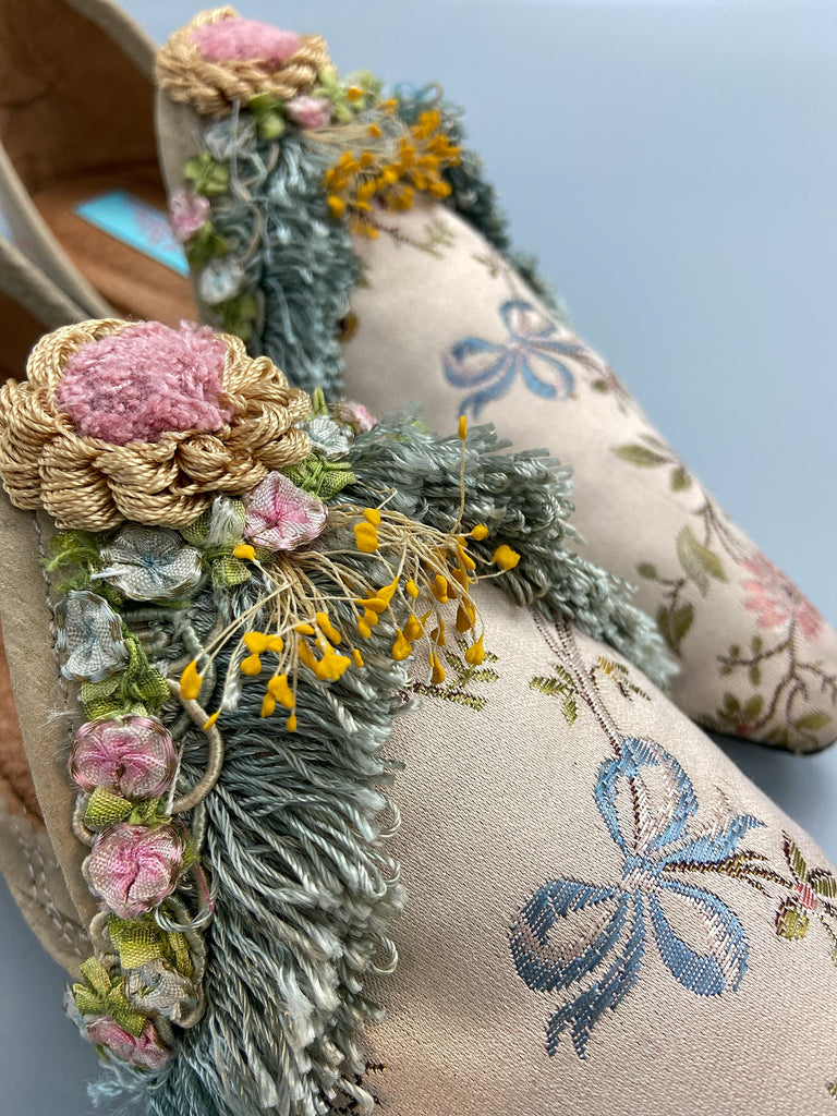 Georgian style silk brocade shoes with blue ribbons and rococo flower trim. Created from antique textiles by the Pavilion Parade studio