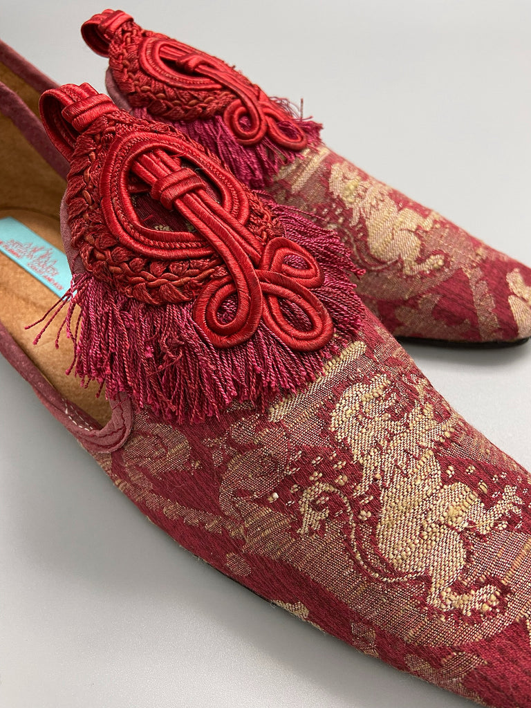 Dark red French brocade slipper shoes with a heraldic design of lions rampant, embellished with antique crimson silk soutache medallions. Created from antique textiles by Pavilion Parade