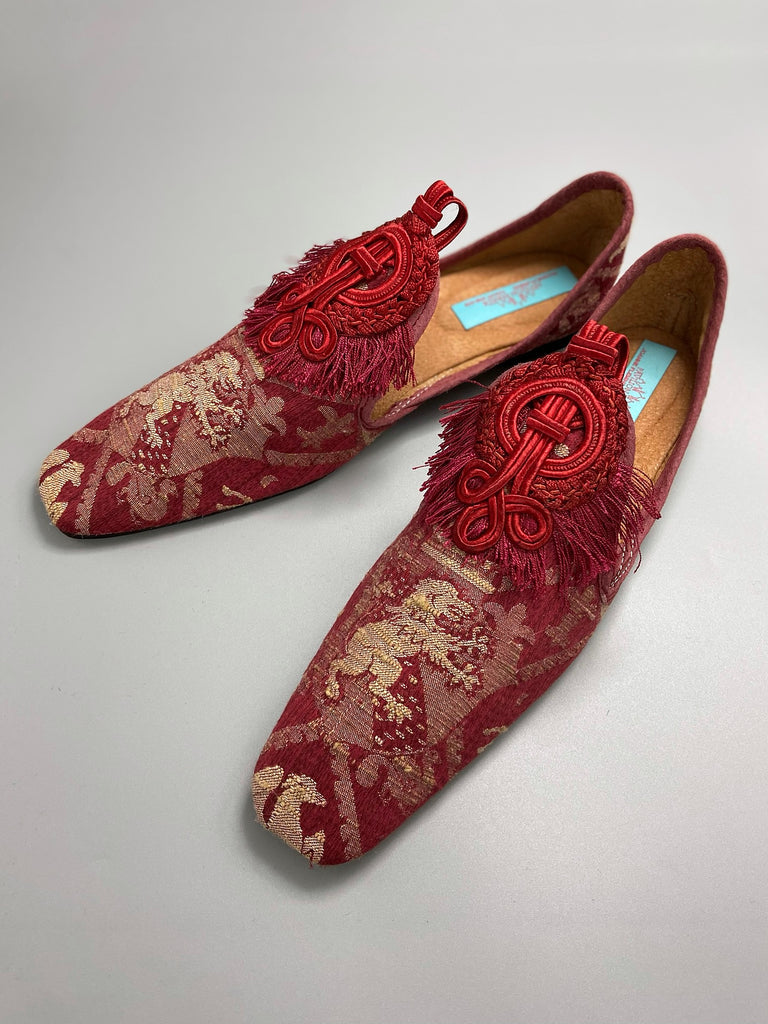 Dark red French brocade slipper shoes with a heraldic design of lions rampant, embellished with antique crimson silk soutache medallions. Created from antique textiles by Pavilion Parade