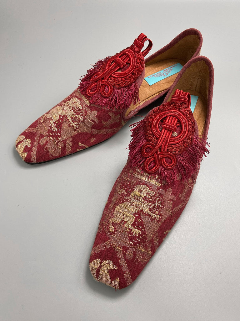 Dark red French brocade slipper shoes with a heraldic design of lions rampant, embellished with antique crimson silk soutache medallions. Created from antique textiles by Pavilion Parade