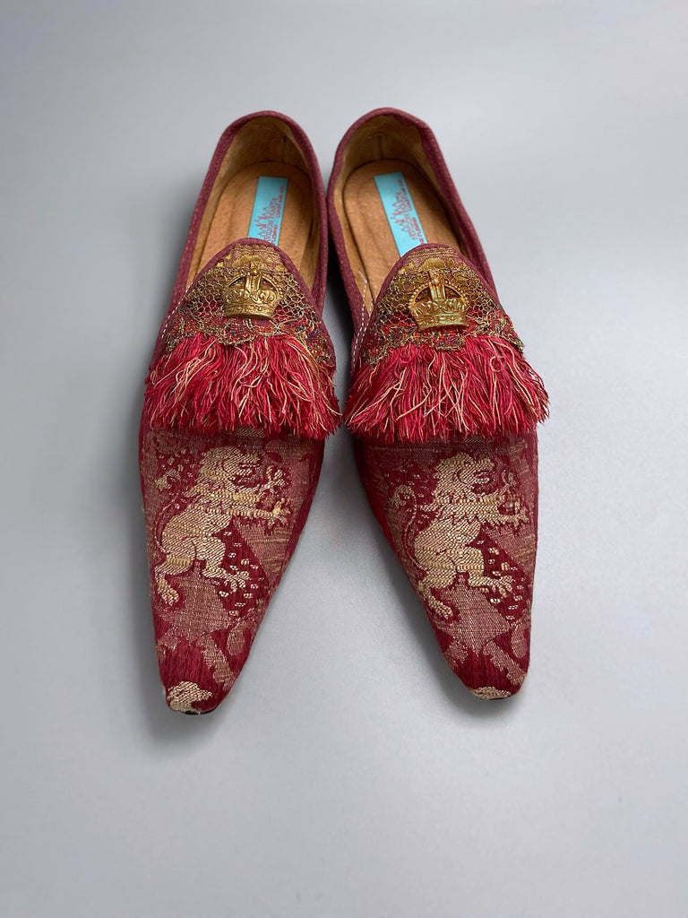 Dark red French brocade slipper shoes with a heraldic design of lions rampant, embellished with early 1800s Florentine silk tassel fringe and aged toleware crowns. Created from antique textiles by Pavilion Parade