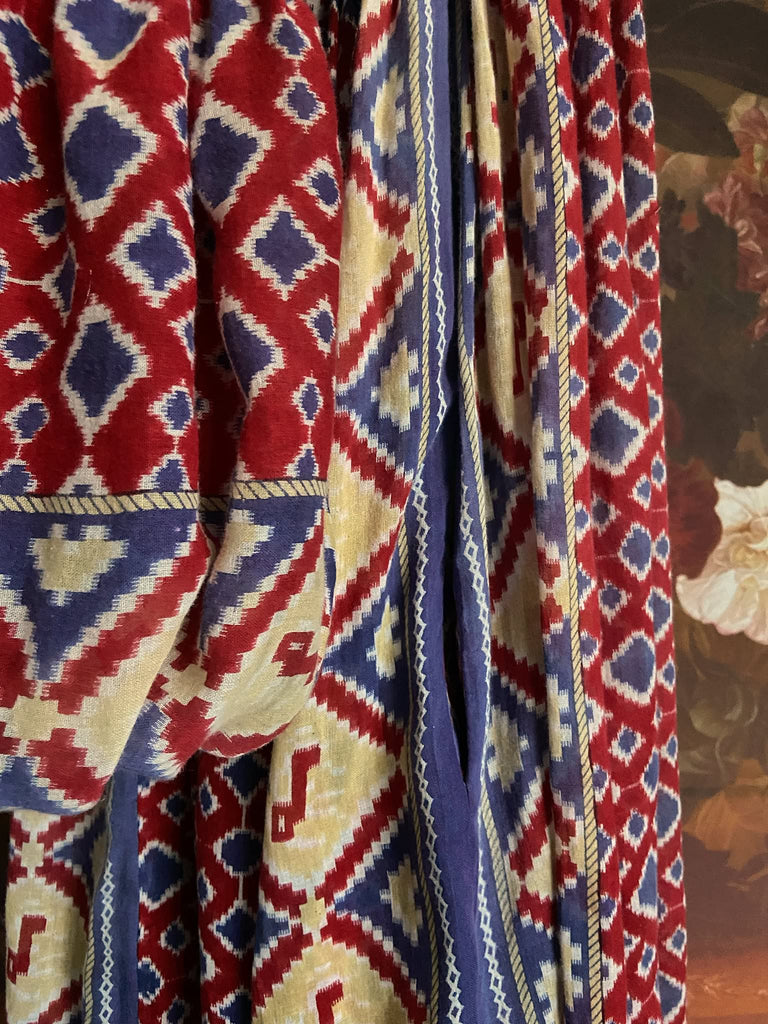 Ruby red and Persian blue printed ikat fine cotton muslin dress with full balloon sleeves, pockets and tiered hem. Bohemian style from the Pavilion Parade studio.