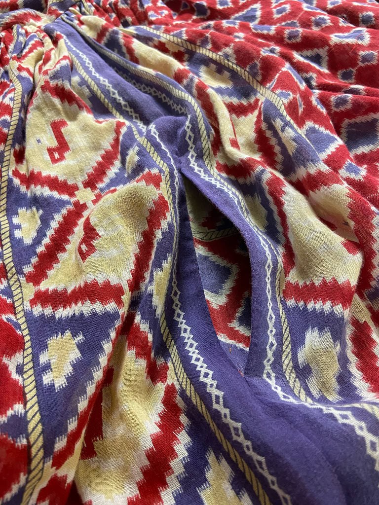 Ruby red and Persian blue printed ikat fine cotton muslin dress with full balloon sleeves, pockets and tiered hem. Bohemian style from the Pavilion Parade studio.