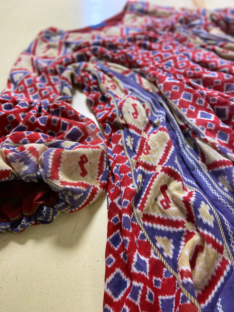 Ruby red and Persian blue printed ikat fine cotton muslin dress with full balloon sleeves, pockets and tiered hem. Bohemian style from the Pavilion Parade studio.