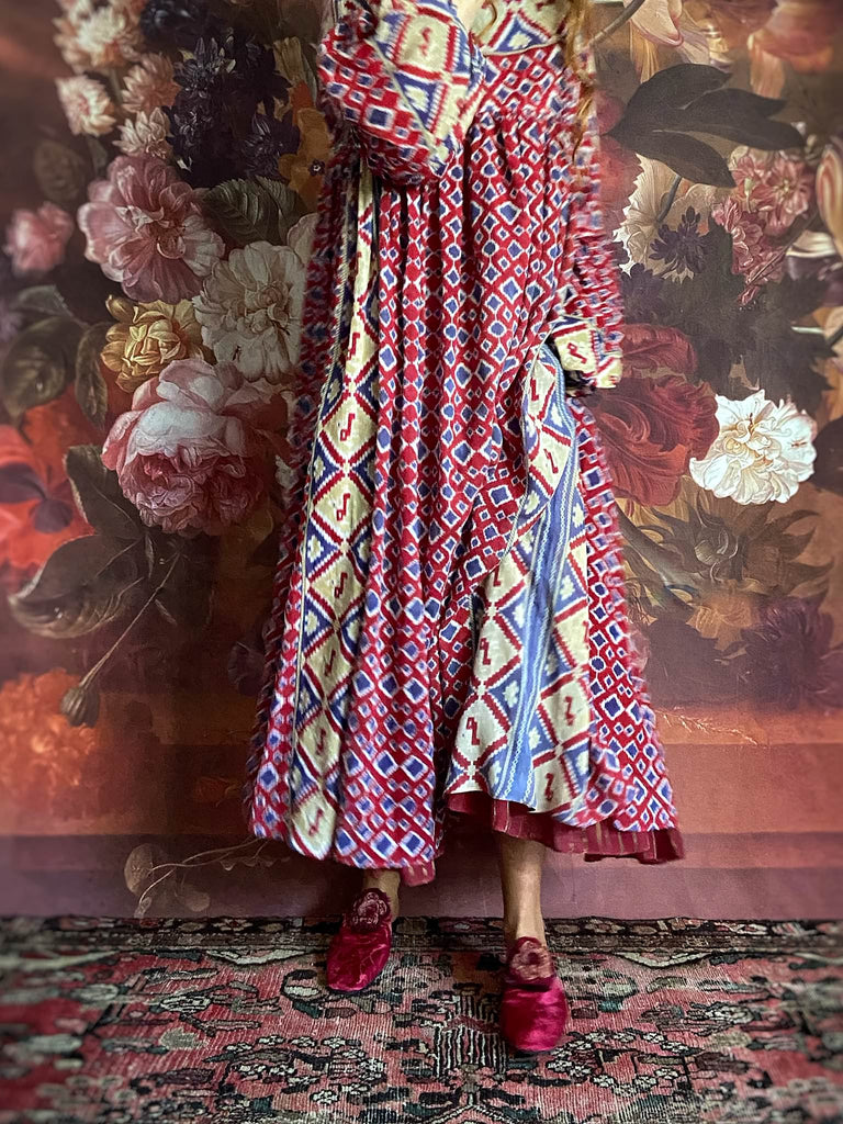 Ruby red and Persian blue printed ikat fine cotton muslin dress with full balloon sleeves, pockets and tiered hem. Bohemian style from the Pavilion Parade studio.