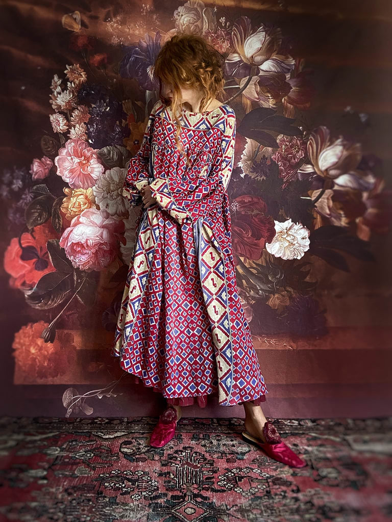 Ruby red and Persian blue printed ikat fine cotton muslin dress with full balloon sleeves, pockets and tiered hem. Bohemian style from the Pavilion Parade studio.