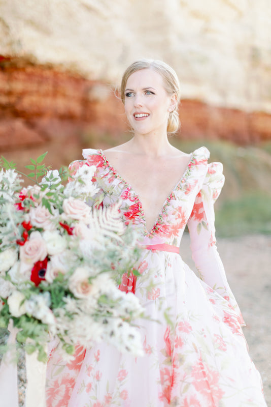Ivory and coral red floral silk organza ball gown  wedding dress with long puffed sleeves and deep illusion plunge neckline. A Flight of Fancy from Pavilion Parade